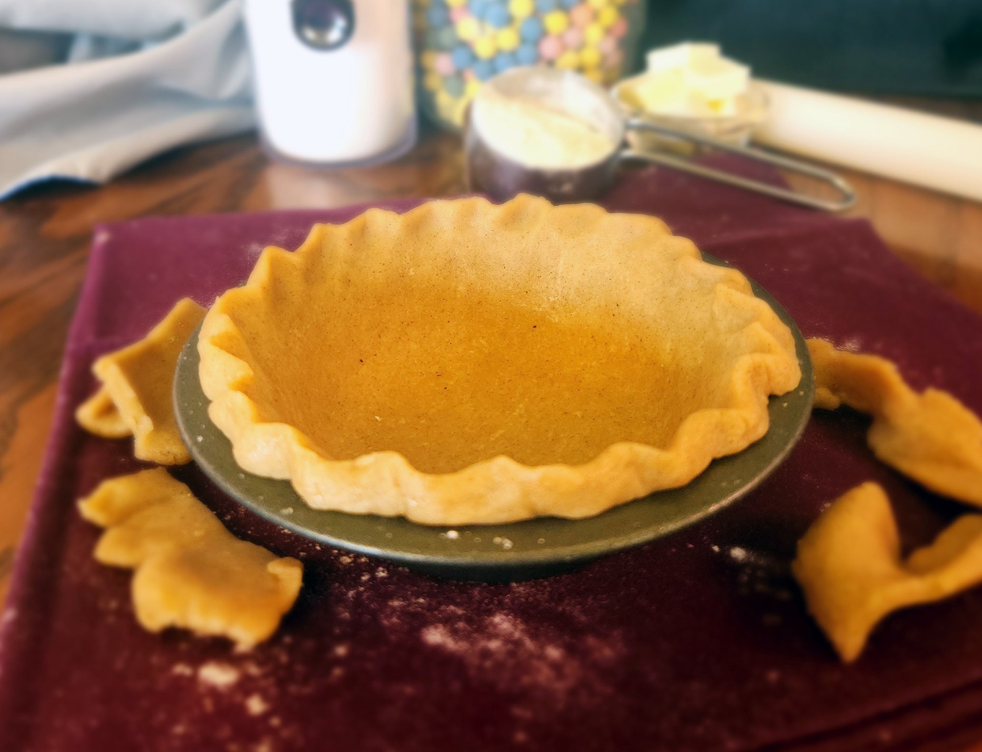 Pie crust in a pie tin with ingredients in the background