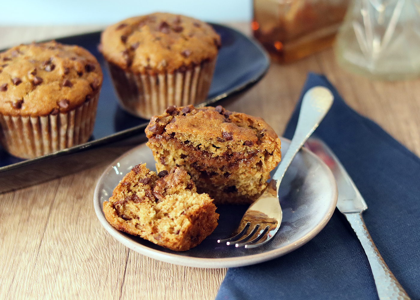 Chocolate Banana Peanut Butter Muffins, one broken open on a plate