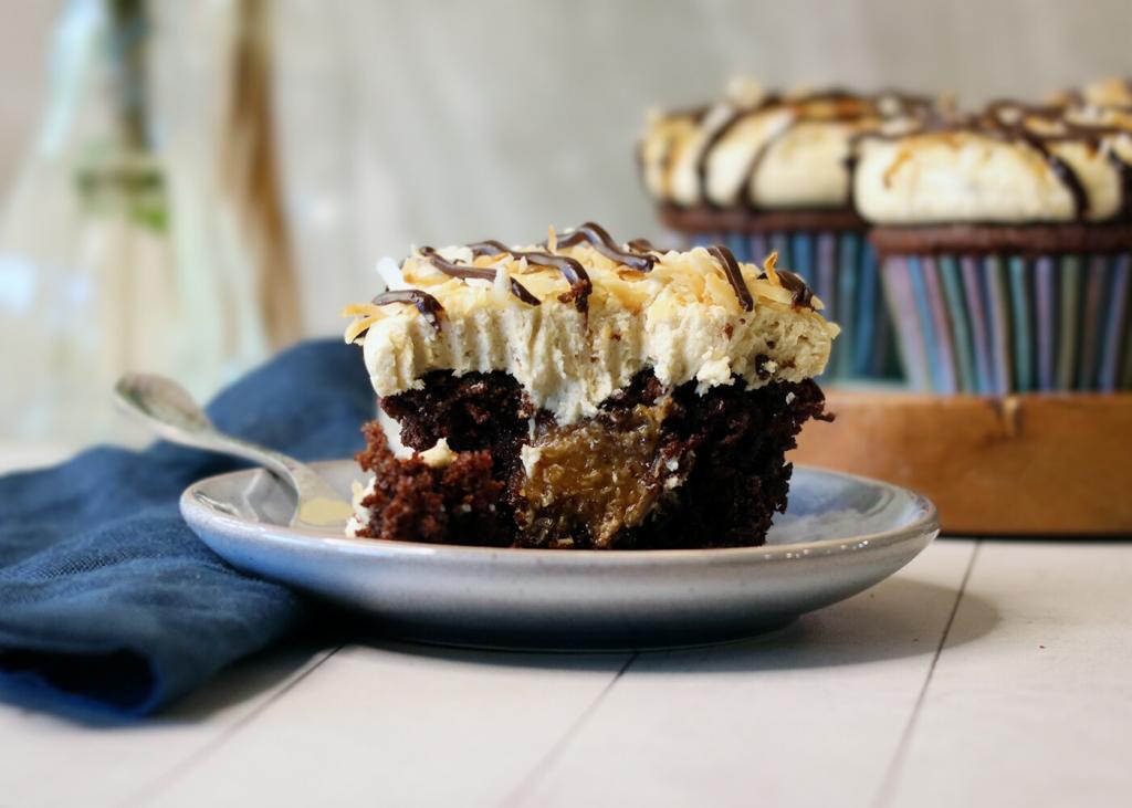 Samoa Cupcake broken open to show caramel coconut filling.