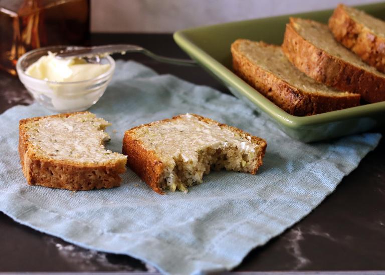 A buttered slice of mom's zucchini bread on a linen napkin