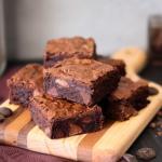 Fudgy Brownies stacked on a wooden board.