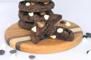 Triple chocolate cookies on round wooden board