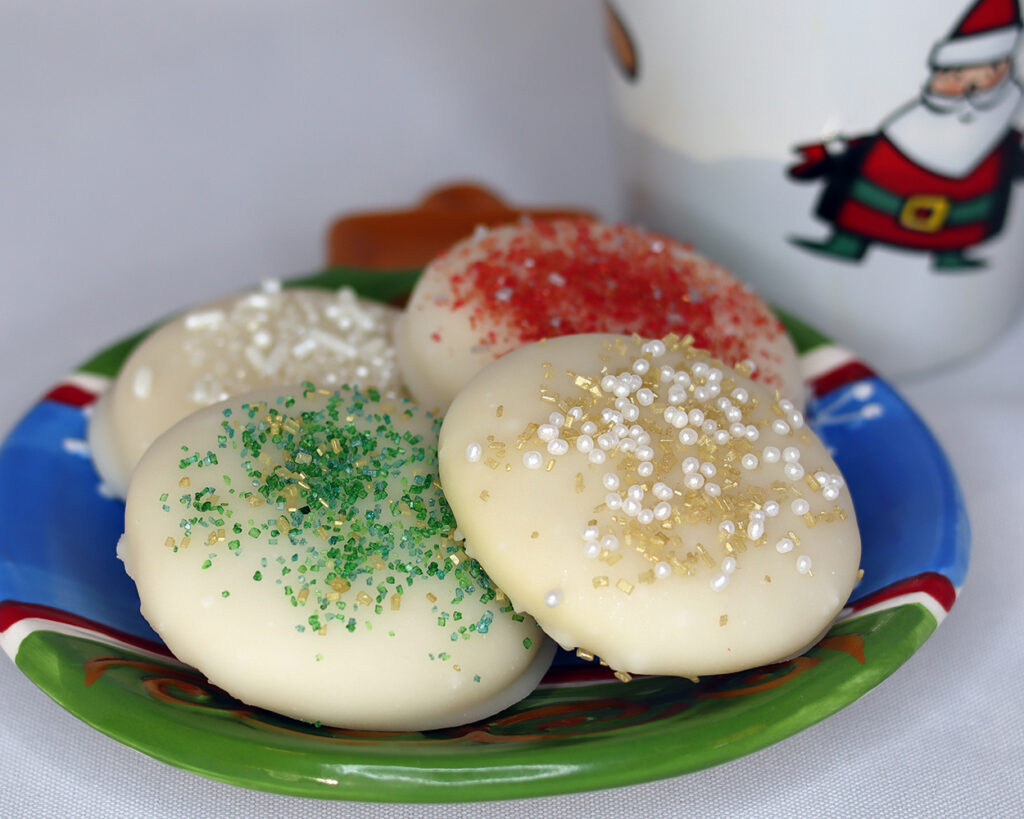 Sugar Cookies on a Christmas plate with a Christmas mug