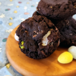 Dark Chocolate Easter Cookies stacked on a small, round, wooden board