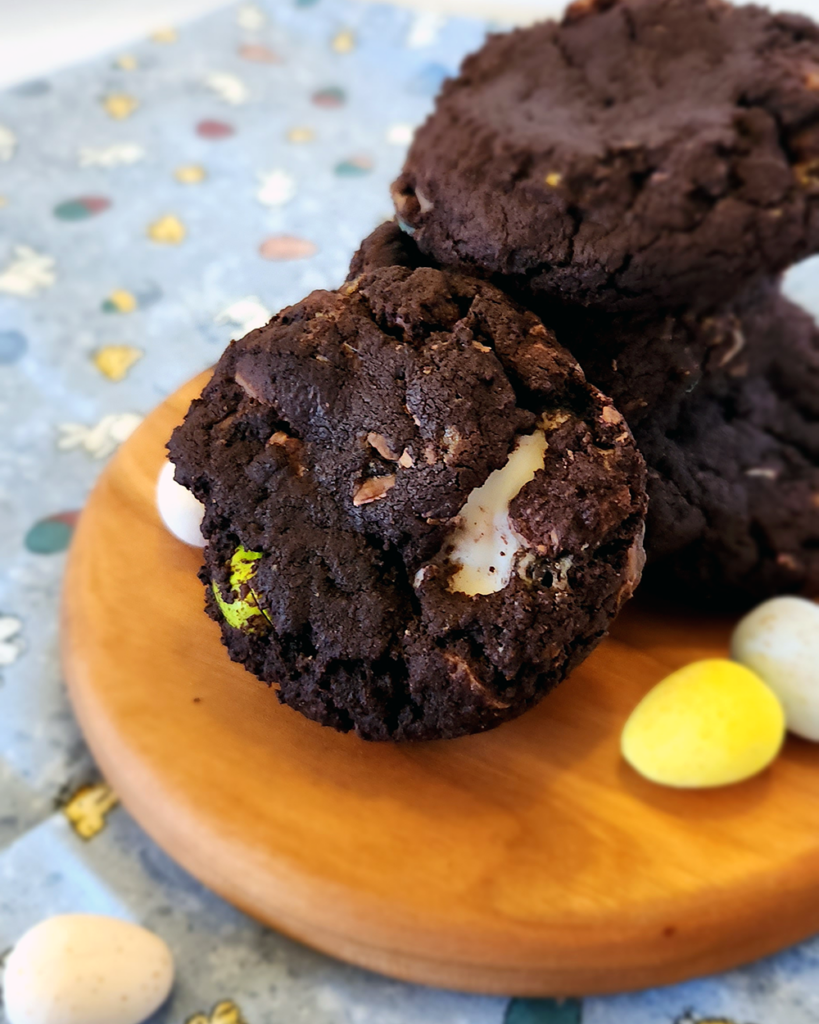 Dark Chocolate Easter Cookies stacked on a small, round, wooden board