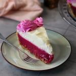 Prickly Pear Lemonade Pie slice showing layers of prickly pear curd and lemon mousse and prickly pear whipped cream garnish.