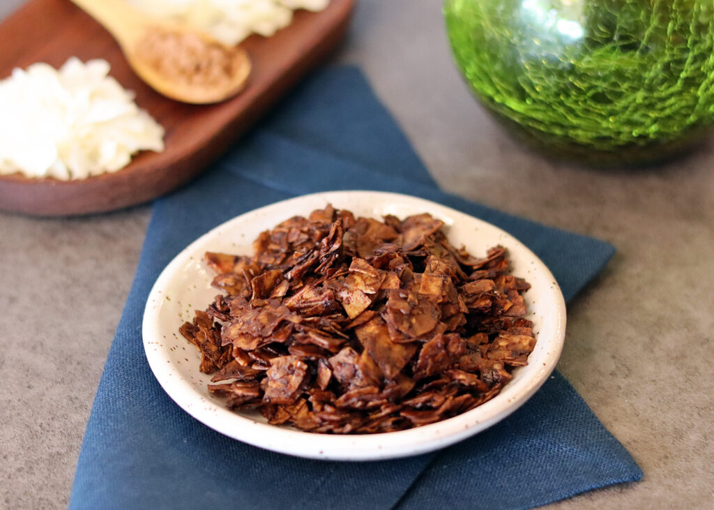 Chocolate Coconut Chips in a small bowl on a blue napkin