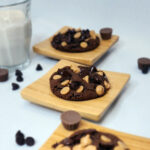 Double Chocolate Chip Cookies on small wooden plates with a glass of milk.