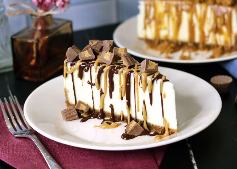 New York Cheesecake slice drizzled with melted peanut butter, hot fudge and chopped peanut butter cup