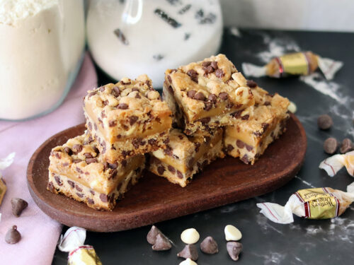 Caramel Chip Bars piled on a small wooden platter