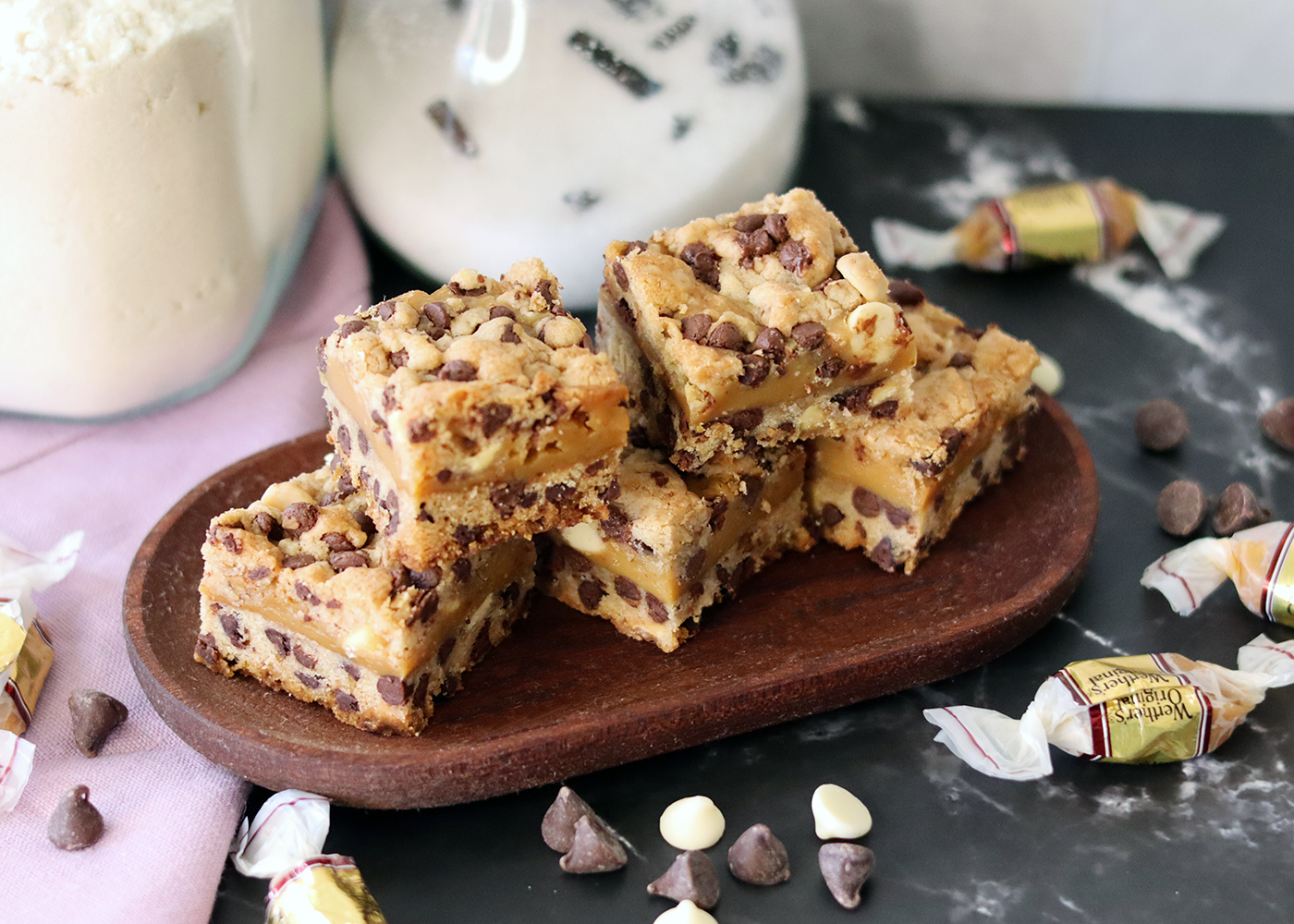 Caramel Chip Bars piled on a small wooden platter