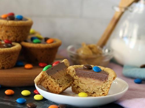 Choco Peanut Butter Cup split open on a small plate. More piled in the background.