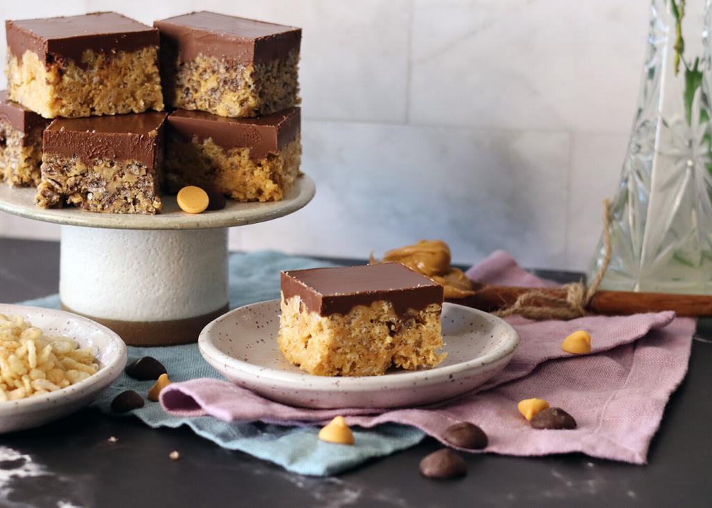 Rice Krispie Frosted Treats piled on a small stand with one on a plate