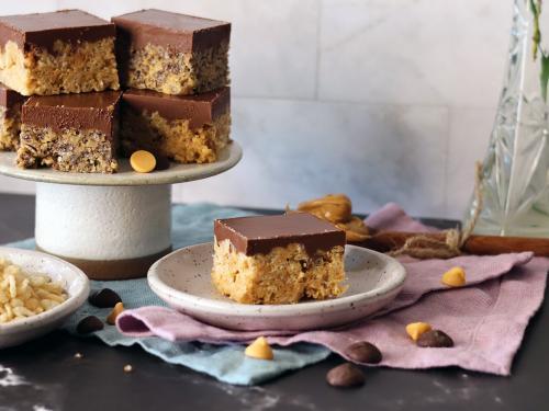 Rice Krispie Frosted Treats piled on a small stand with one on a plate