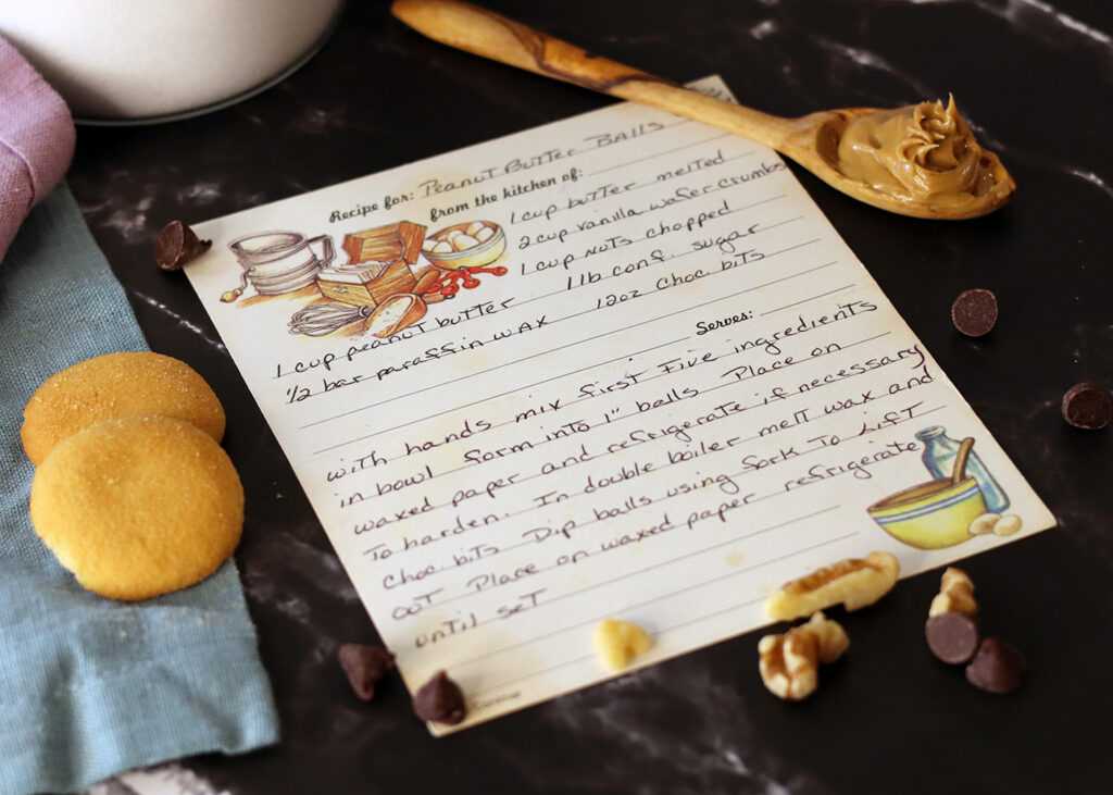 Peanut Butter Balls recipe card on a counter with ingredients scattered around