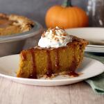 Caramel Toffee Pumpkin Pie slice with whipped cream, caramel and a sprinkle of toffee