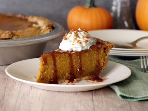 Caramel Toffee Pumpkin Pie slice with whipped cream, caramel and a sprinkle of toffee