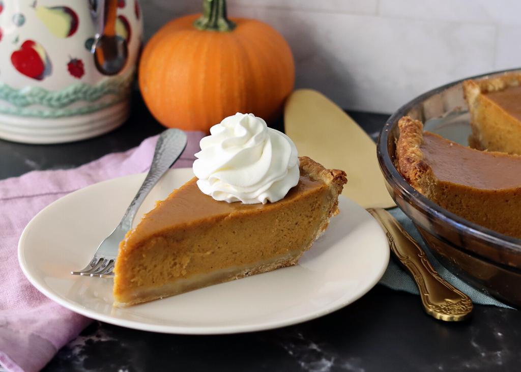 Pumpkin Pie slice topped with a swirl of whipped cream.