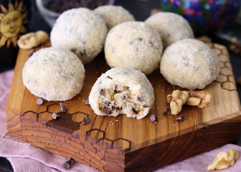 Sugar Coated Melt-Aways on a small wooden serving board with a bite out of one.