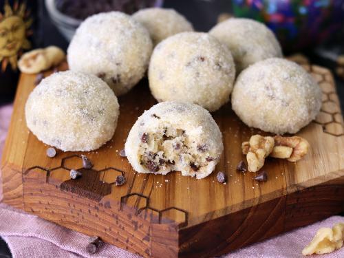 Sugar Coated Melt-Aways on a small wooden serving board with a bite out of one.