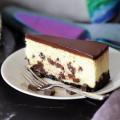 Chocolate Chunk Cheesecake slice on a white plate.
