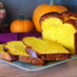 Sliced loaf of pumpkin brioche arranged on a glass plate