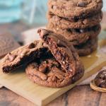 Ferrero Rocher Chocolate Chip Cookies stacked on a small board with one broken open to show the interior texture.