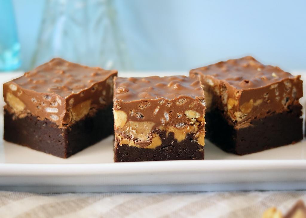 Peanut Butter Crunch Brownies arranged on a white plate.