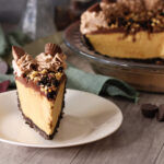 Peanut Butter Party Pie slice on a white plate with the full pie in the background