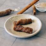 Churro Caramels on a small plate showing a spiral texture and cinnamon sugar coating.