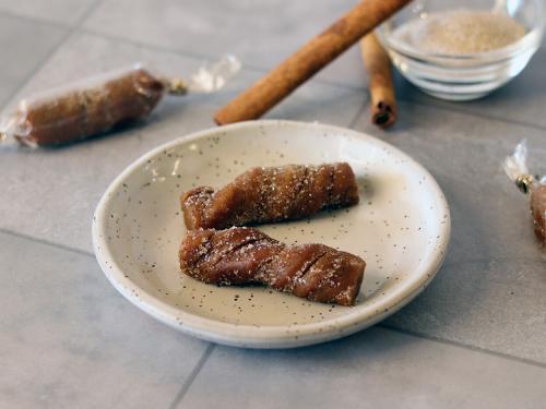 Churro Caramels on a small plate showing a spiral texture and cinnamon sugar coating.