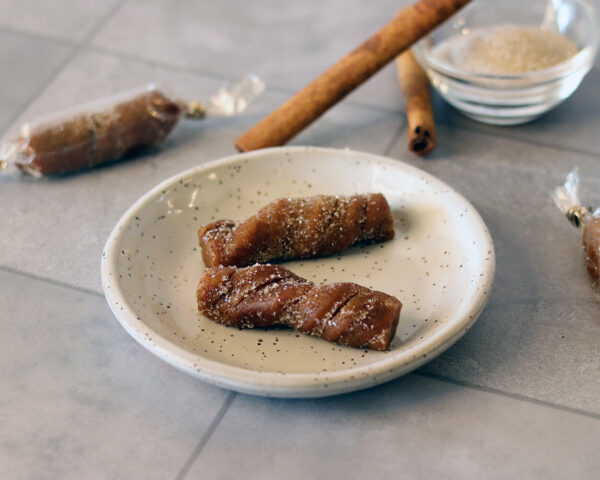 Churro Caramels on a small plate showing a spiral texture and cinnamon sugar coating.