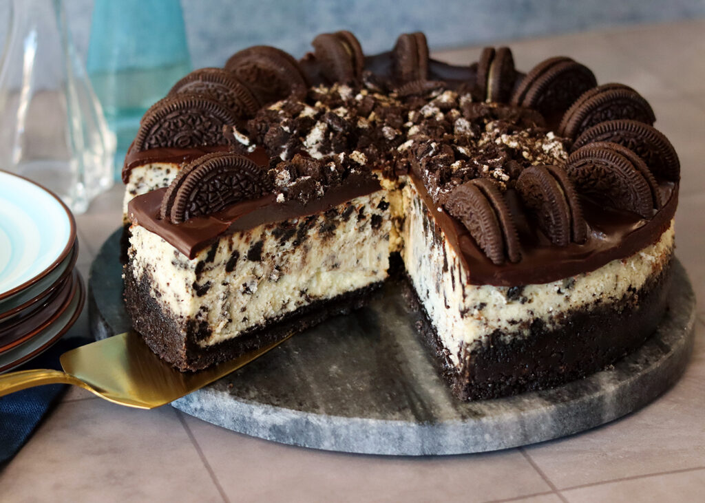 Cookies'N Cream Cheesecake with a slice being served