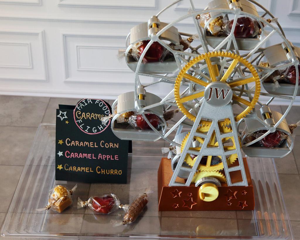 Three flavors of caramel - caramel corn, caramel apple and caramel churro - arranged in the gondolas of a small Ferris wheel