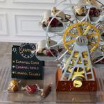 Three flavors of caramel - caramel corn, caramel apple and caramel churro - arranged in the gondolas of a small Ferris wheel