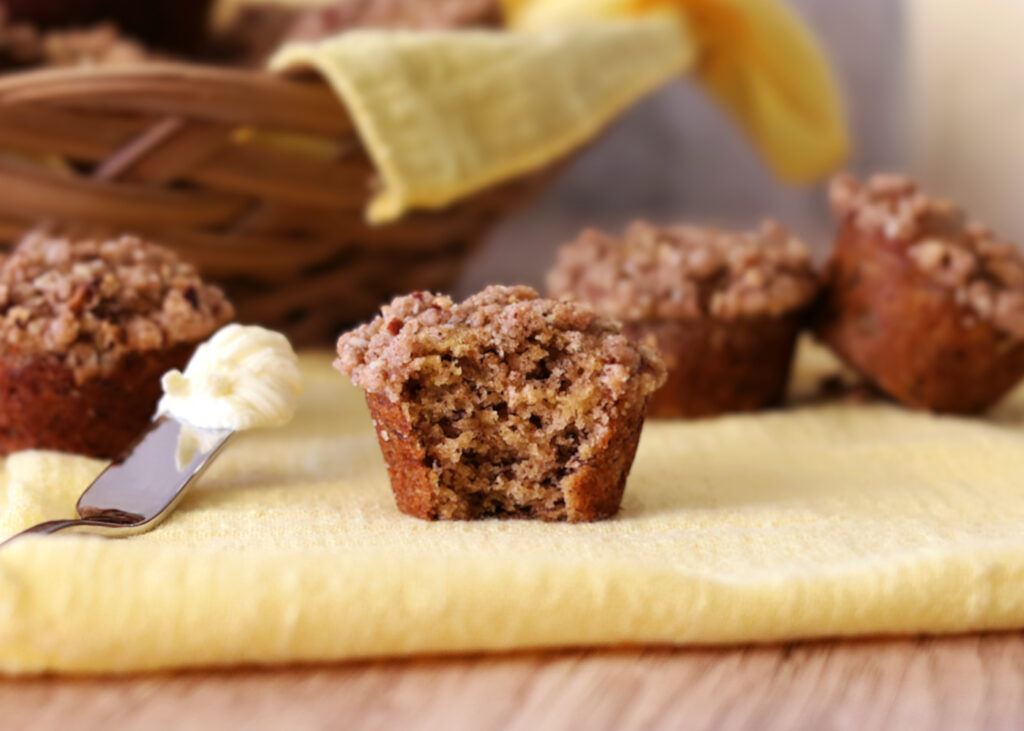 Mini Banana Crumb Muffin with a bite taken out of it.