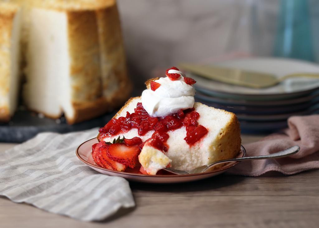 Angel Food Cake served with macerated strawberries and whipped cream