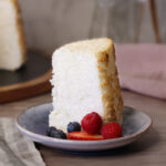 A slice of Angel Food Cake served plain with a few berries.