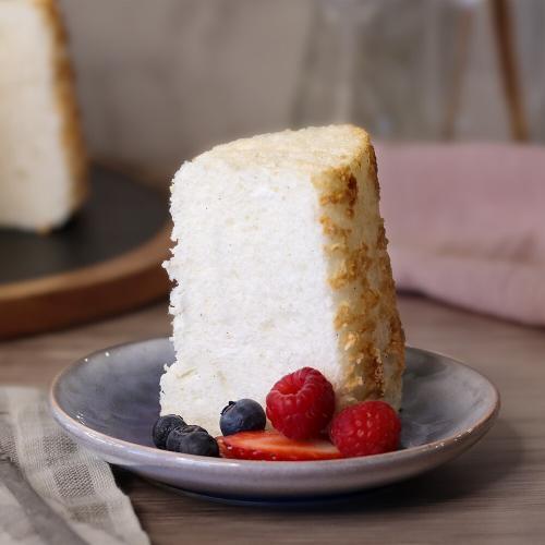 A slice of Angel Food Cake served plain with a few berries.