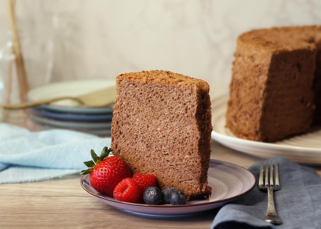 Cocoa Angel Food Cake slice on a plate with berries.