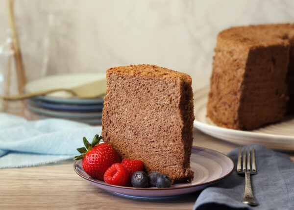 Cocoa Angel Food Cake slice on a plate with berries.