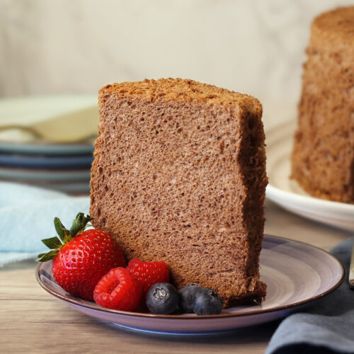 Cocoa Angel Food Cake slice on a plate with berries.