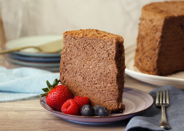 Cocoa Angel Food Cake slice on a plate with berries.