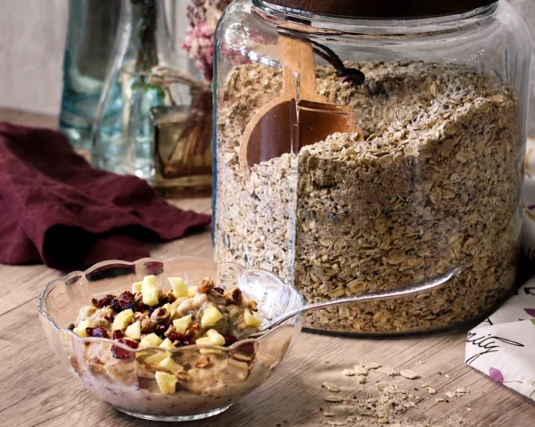 A jar of DIY 100cal Oatmeal Mix next to a prepared bowl of oatmeal.