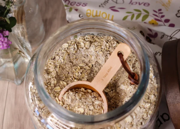 A view of the DIY 100cal Oatmeal Mix inside the jar with a scoop.