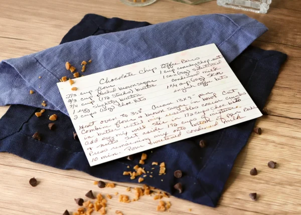 Chocolate Chip Toffee Bars hand-written recipe card with a scattering of ingredients.