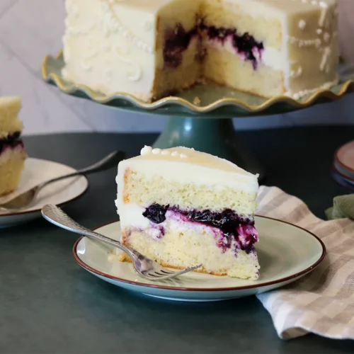Lemon Gold Cake slice showing the delicate crumb and rich blueberry filling.