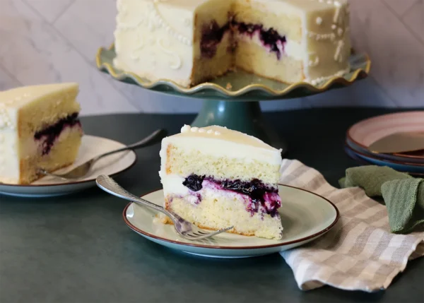 Lemon Gold Cake slice showing the delicate crumb and rich blueberry filling.