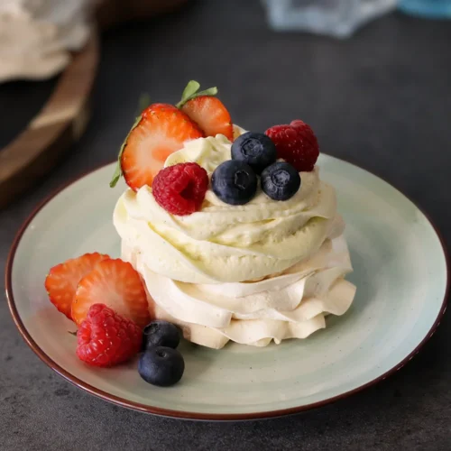 Mini Pavlova served with cheesecake mousse and fresh berries.