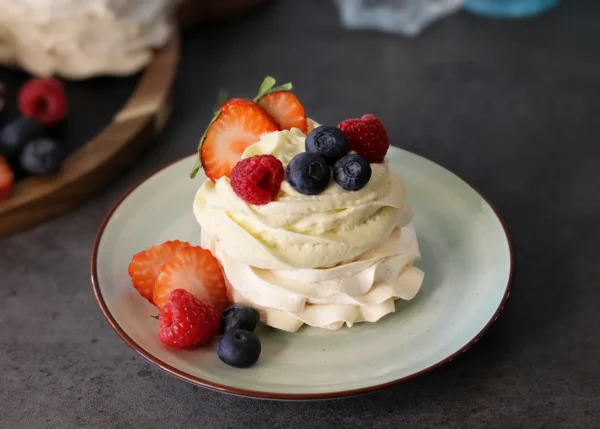 Mini Pavlova served with cheesecake mousse and fresh berries.